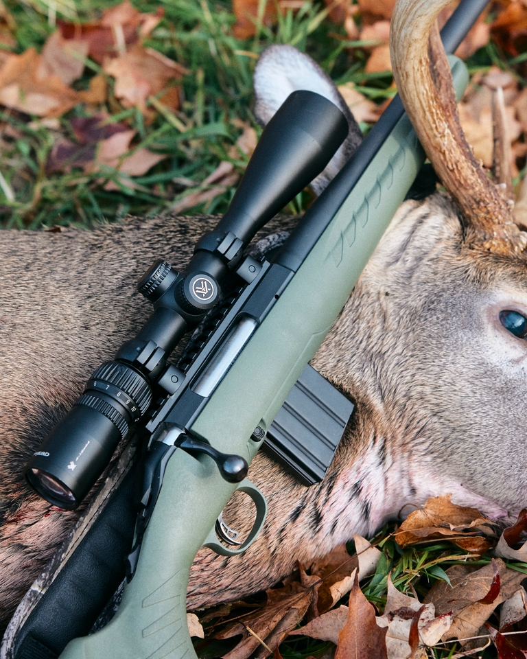 A rifle laying on a deer, carry hunting rifles safely concept. 