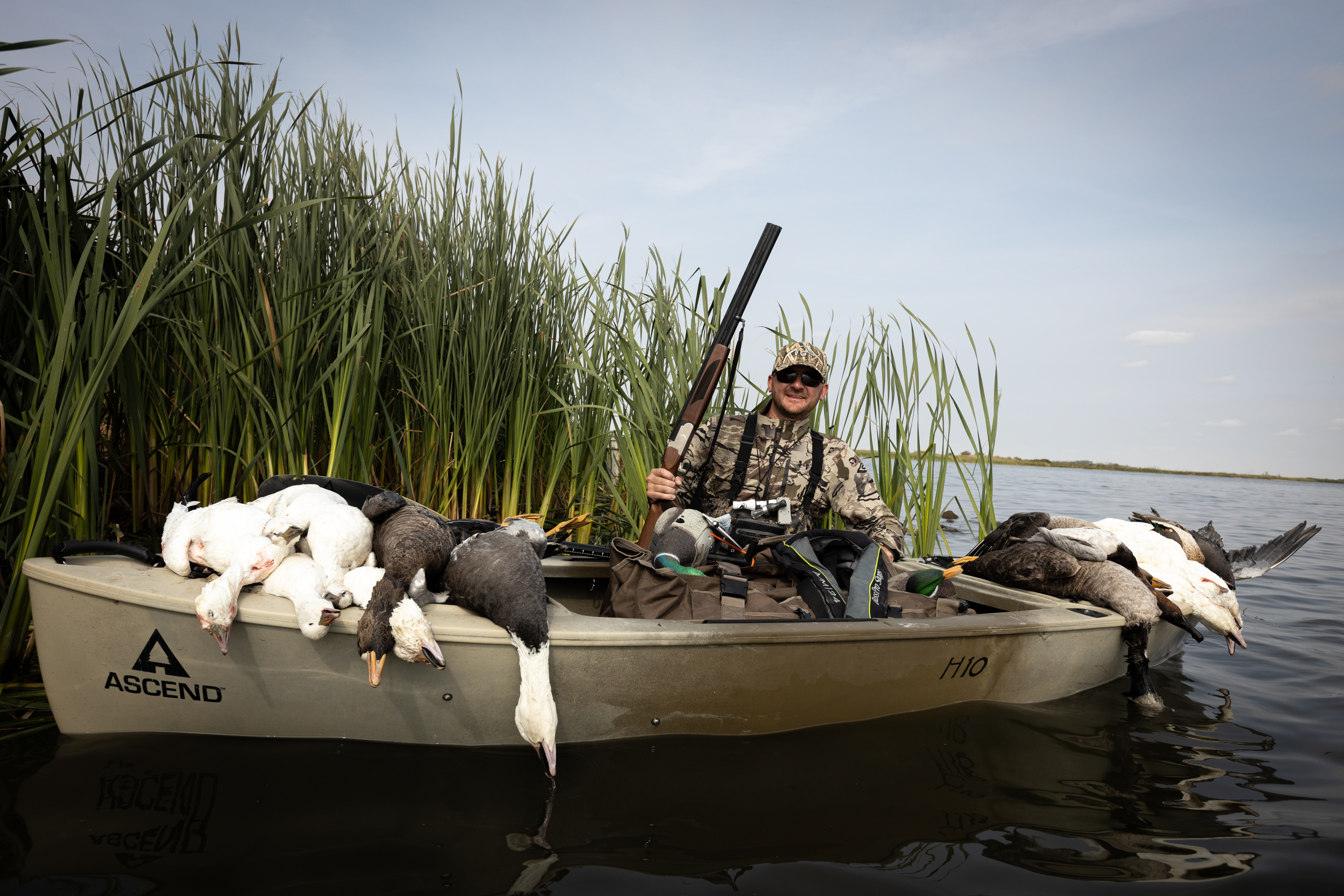 A hunter with a boat full of ducks after a hunt, hunting with a bird dog concept. 