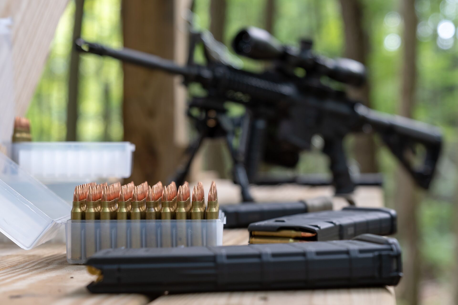 A set of ammunition in focus with a rifle blurred behind, represents understanding calibers,