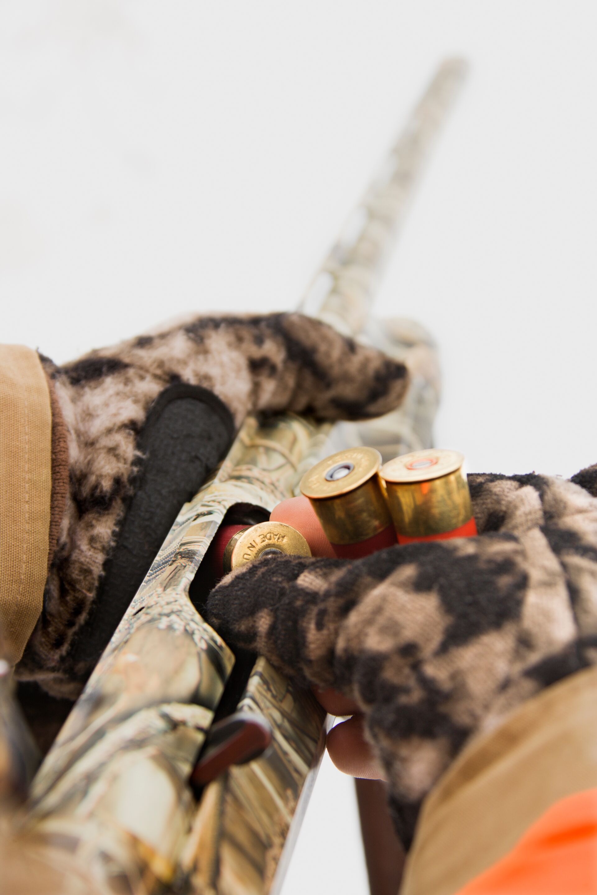 Close-up of a hunter putting shells into a shotgun for mallard duck hunting.