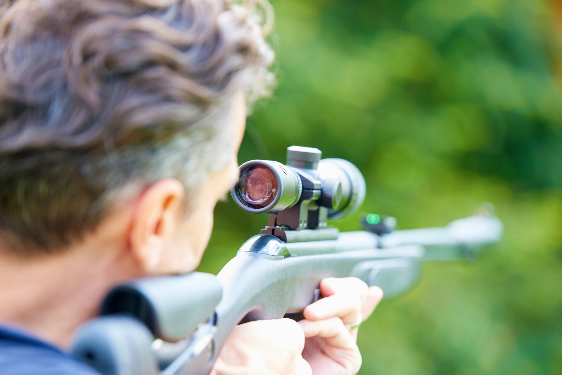 A hunter aims an air rifle. 