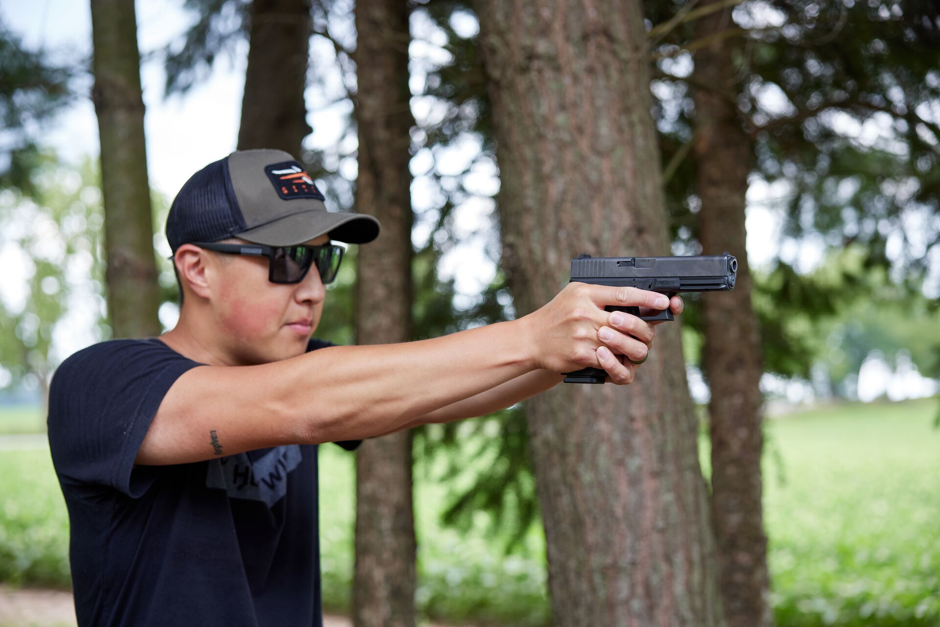 A hunter aims a Glock in the field. 