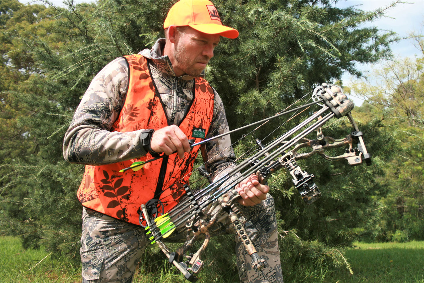 Hunter in blaze orange vest with bow and arrows, safety and hunting for beginners concept. 
