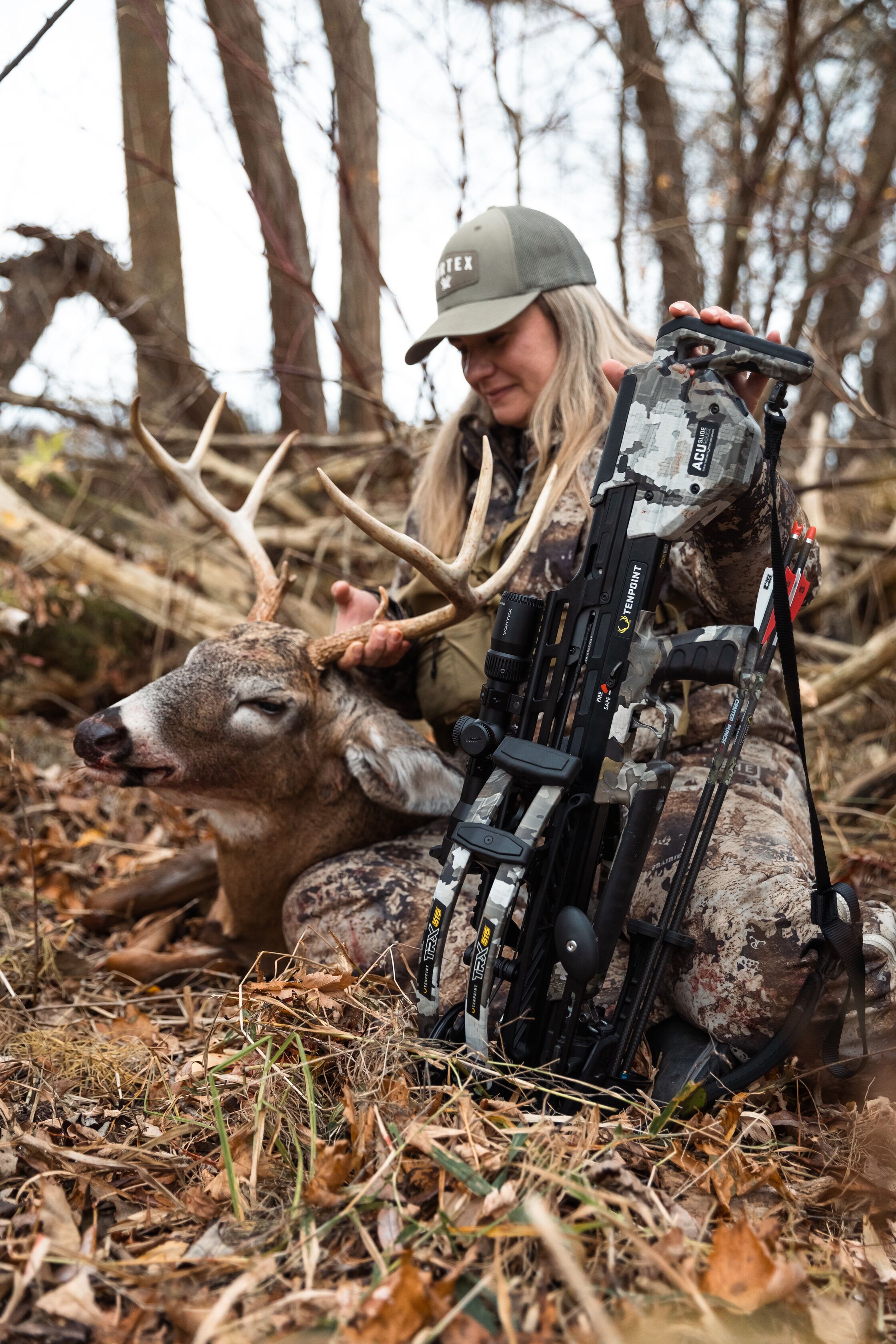 Female hunter sits with bow and deer after hunt, how do I start hunting concept.