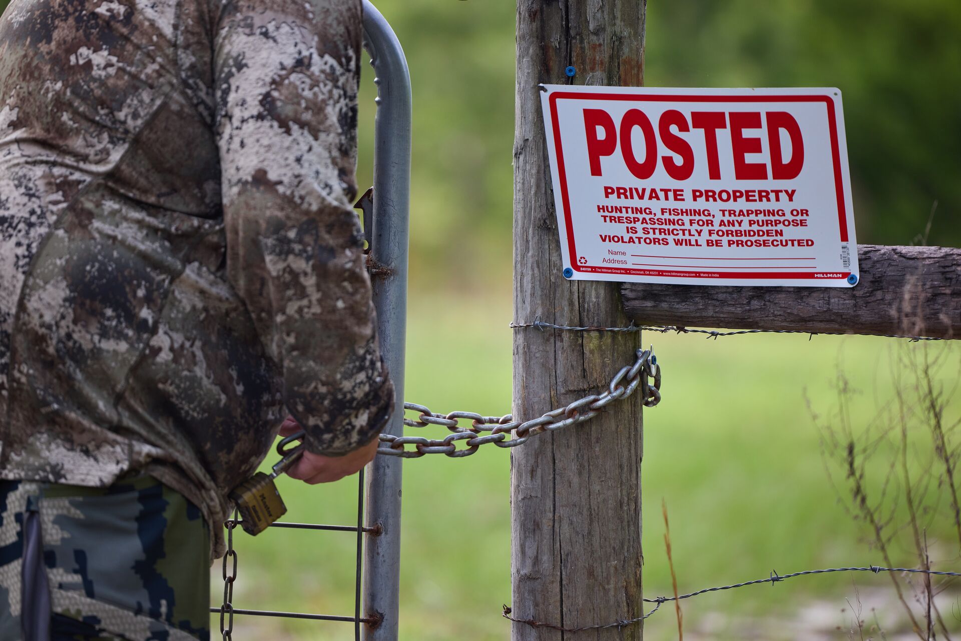 Hunter next to private access sign for hunting land. 