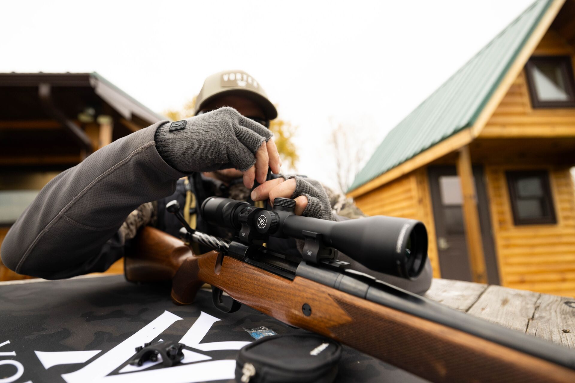 Hunter adjusts a rifle scope. 