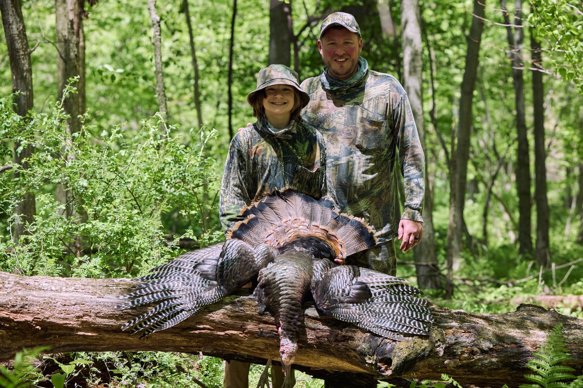 Man and boy smile proudly with turkey after hunt, beginner hunting tips concept. 
