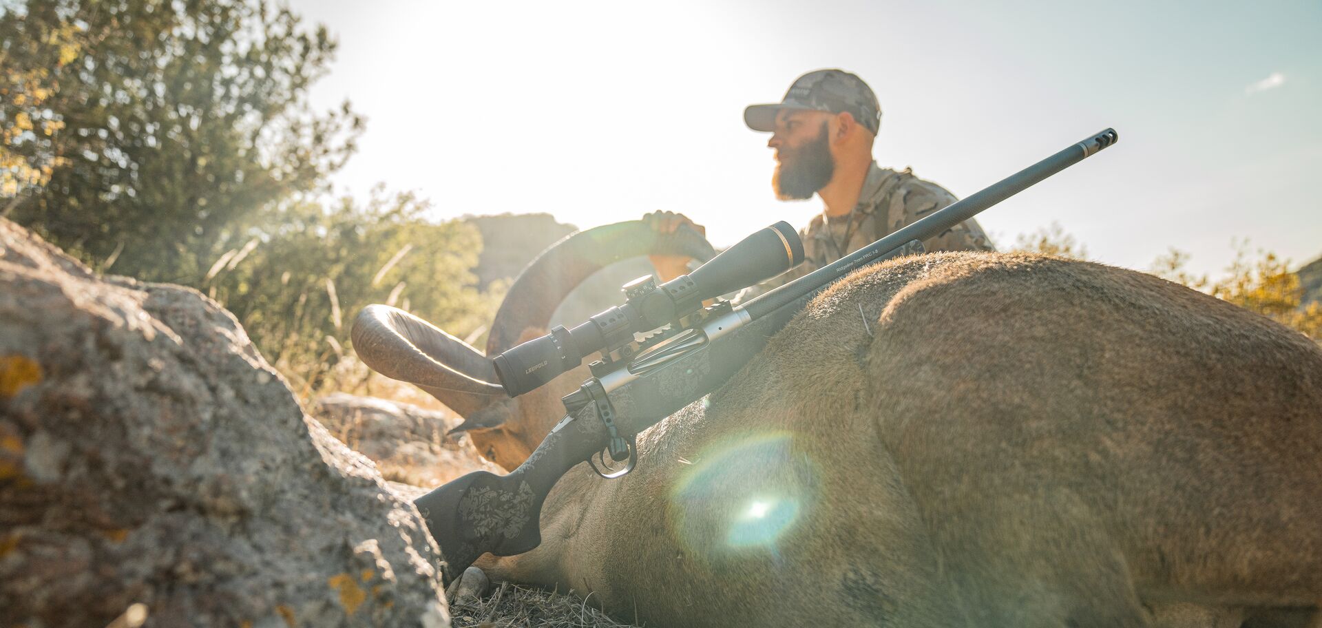 Hunter with big game rifle and ram after hunt, using big game cartridges concept.