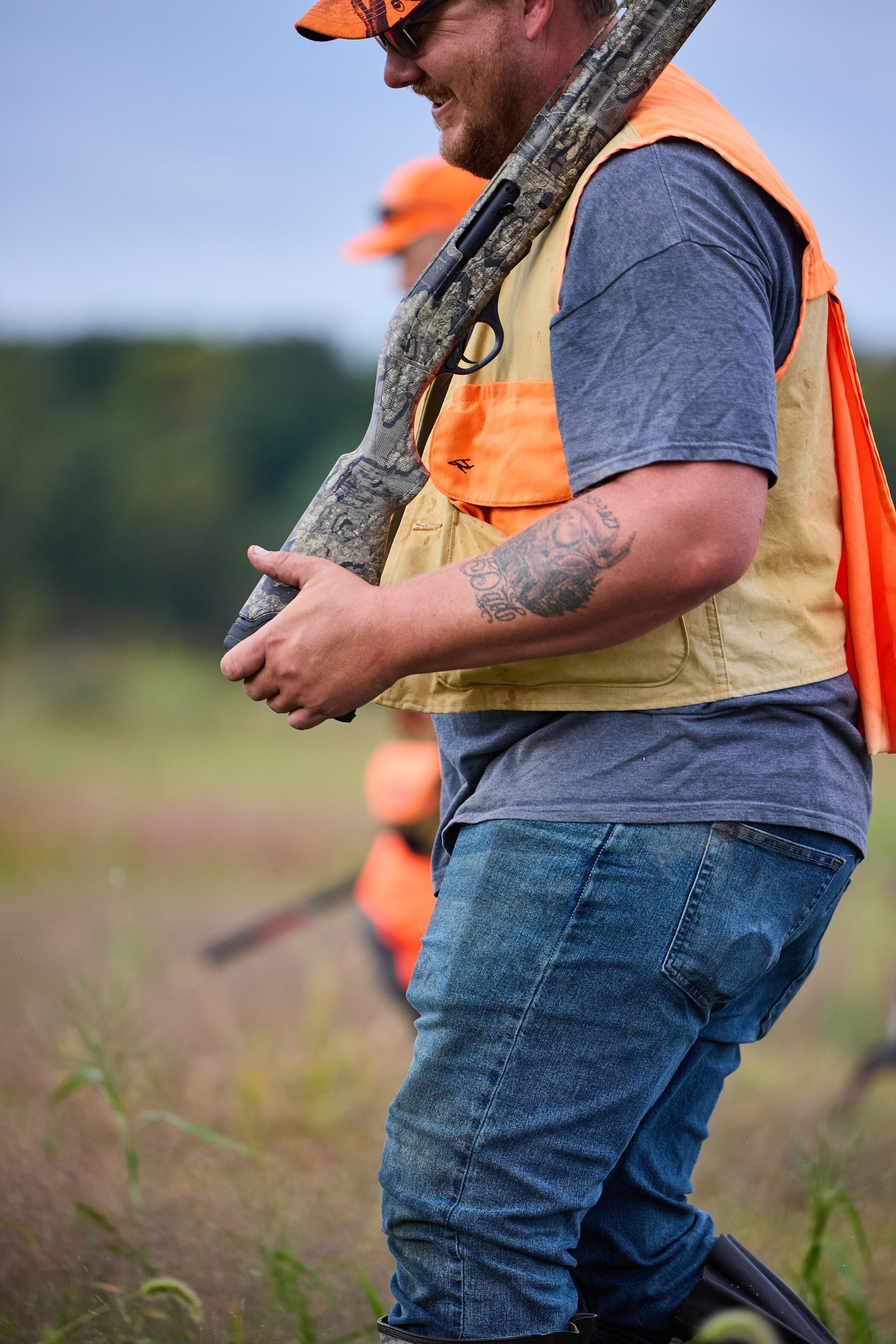Hunter in orange walks with shotgun, pheasant season Montana concept. 