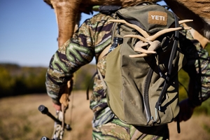 Hunter carries full pack and deer decoy, hunting gear for beginners concept.