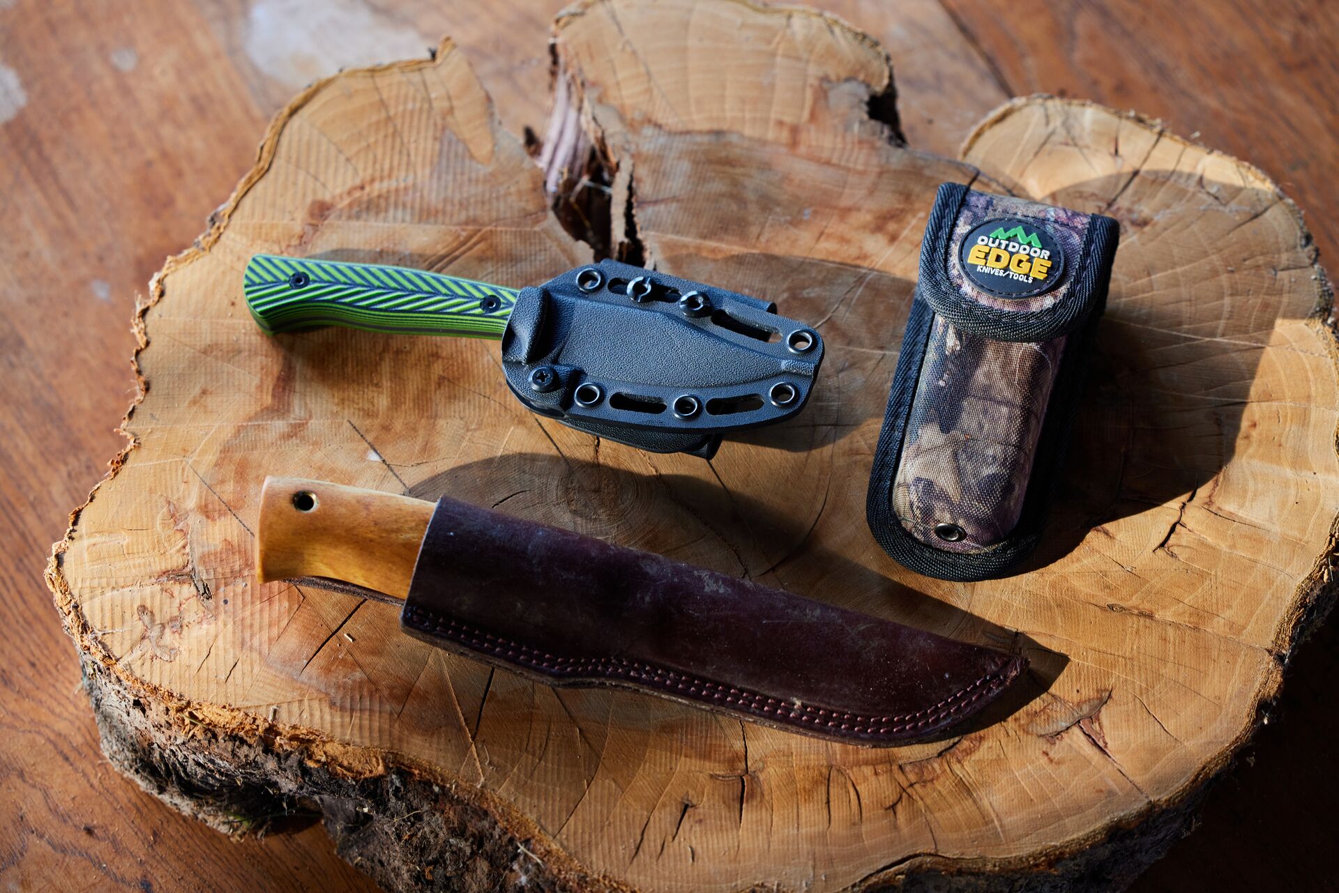 Three hunting knives on a tree stump, hunting equipment list concept. 