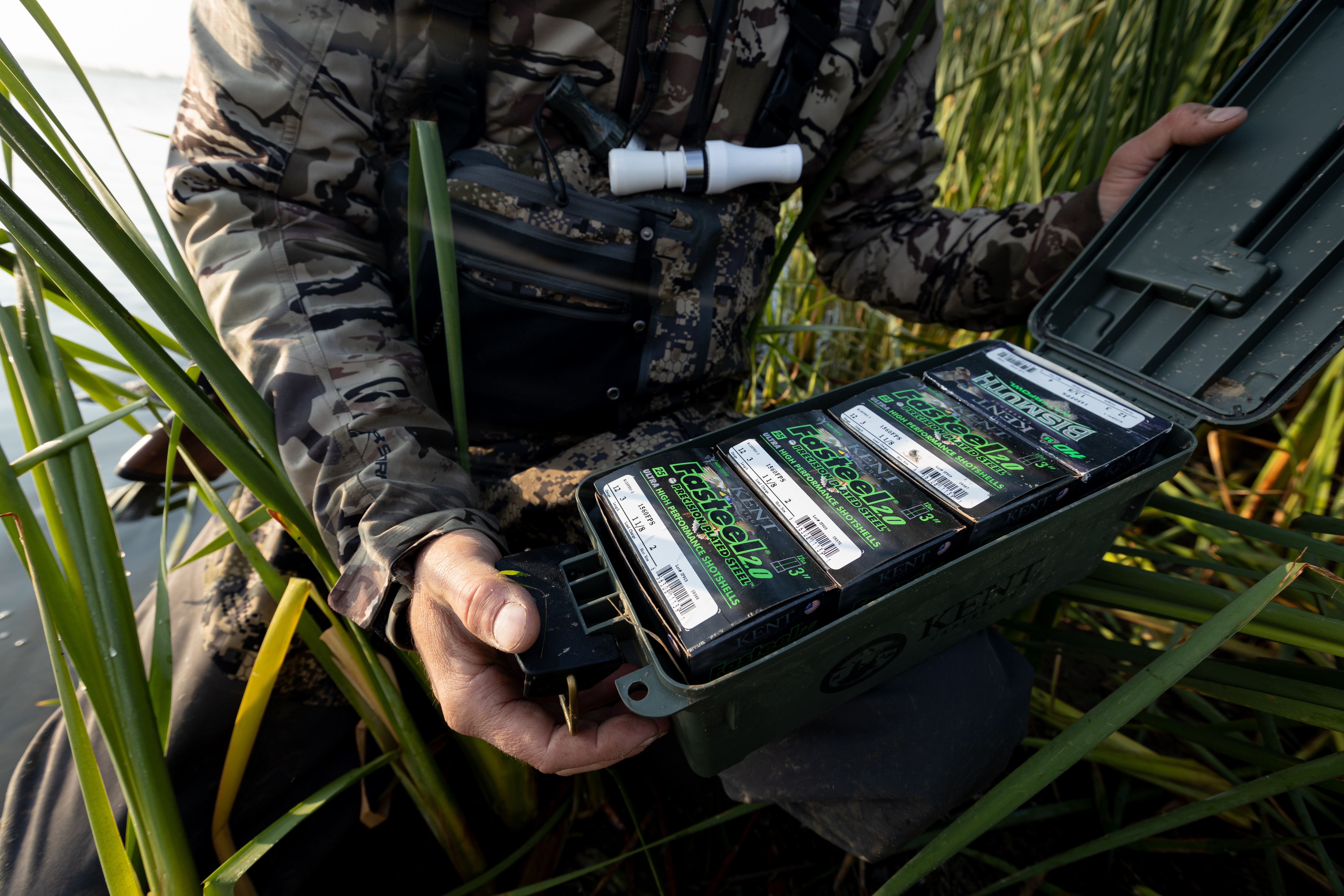 A hunter shows a box of shotgun shells, choosing the right hunting caliber concept. 