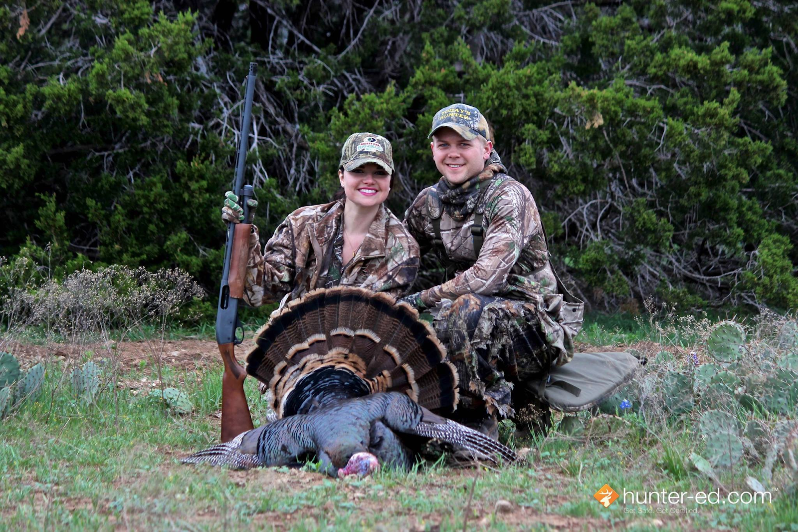 A man and woman with a turkey kill, hunting safely with someone you love. 