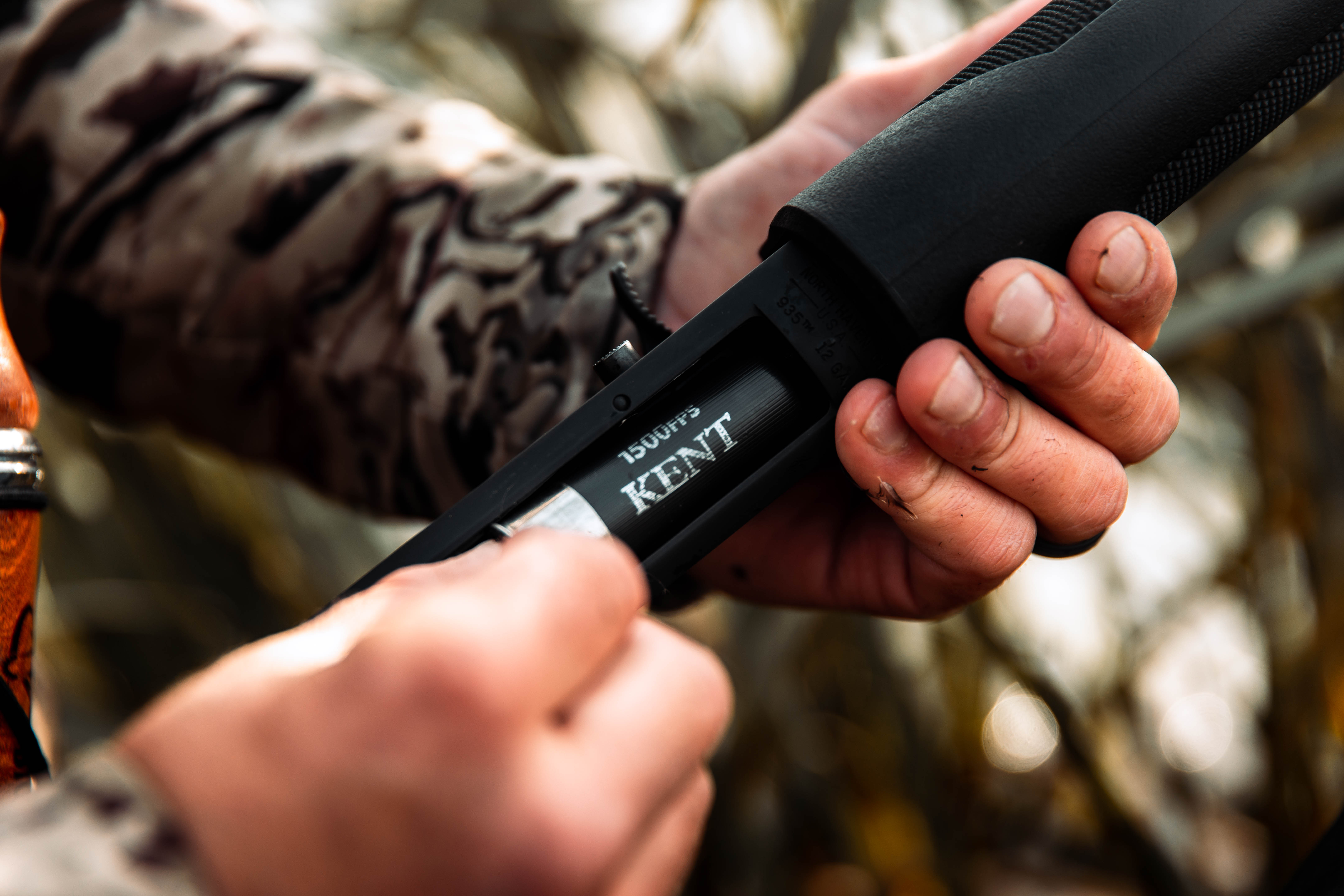 Close-up of a hunter putting a shell into a shotgun, hunt for wild game recipes concept. 