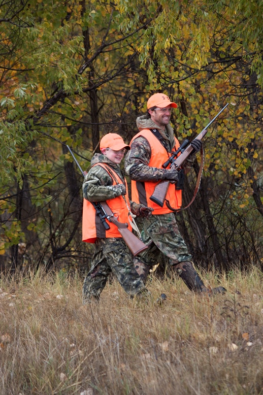 Hunters wearing blaze orange, hunter safety with Hunter-Ed concept. 